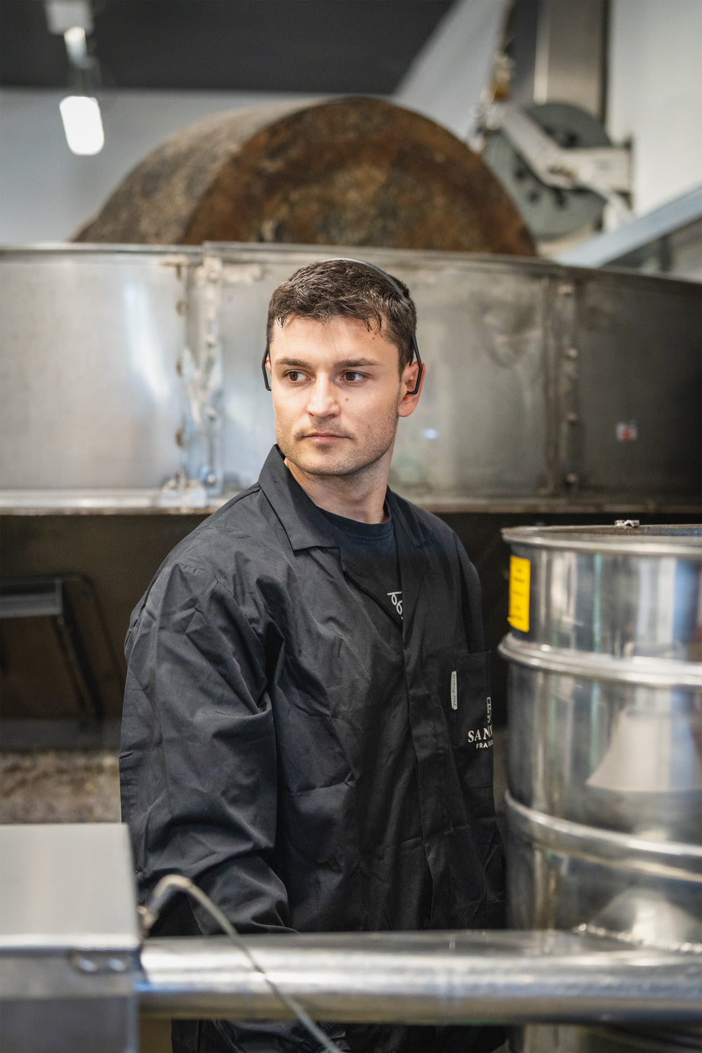 Un operatore del frantoio accanto ai macchinari di lavorazione